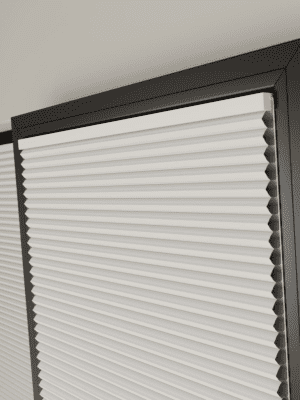 Clic Honeycomb This image shows white clic honey comb blinds fitted onto a black window frame