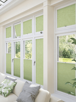 Perfect Fit Blinds This image shows light green perfect-fit blinds attached to white window frames. SOme are open and some are closed.