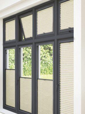 Perfect Fit Honeycomb This image shows sand coloured perfect-fit honeycomb blinds, half up and half down, fitted onto black window frames.